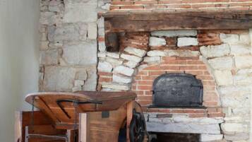 Una chimenea rústica de piedra con un banco de madera al frente.