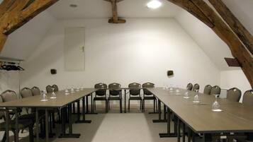 A conference room with a long table, chairs, and wine glasses.