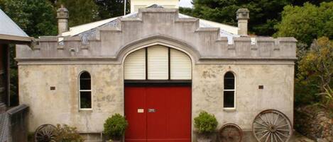 A building with a red door, arched windows, and a stone facade.