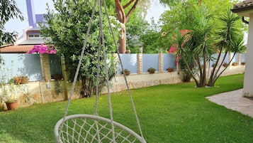 Relax in a serene outdoor space surrounded by lush greenery and a tranquil atmosphere.
