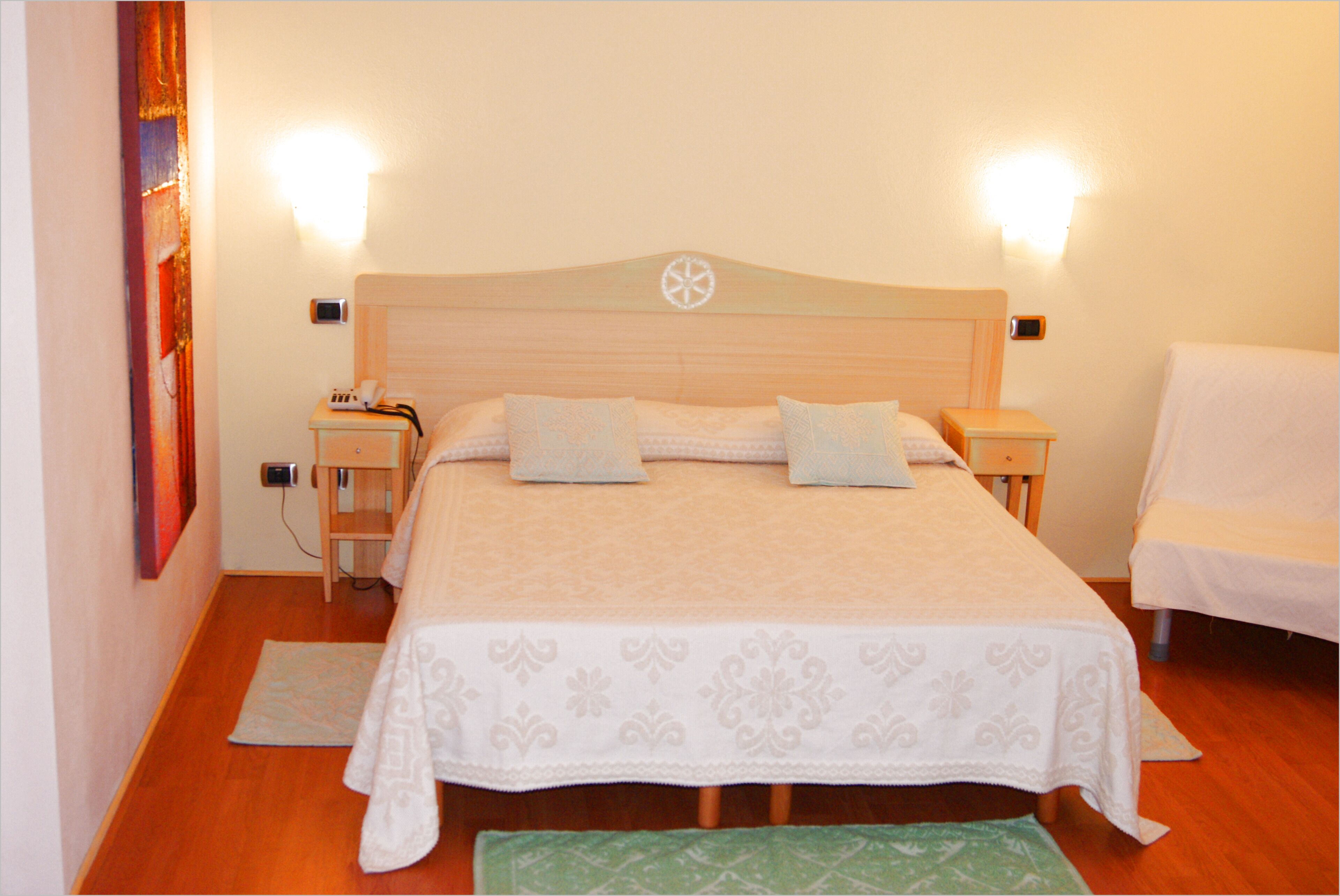 A neatly arranged bedroom with a large bed, bedside tables, and a chair.