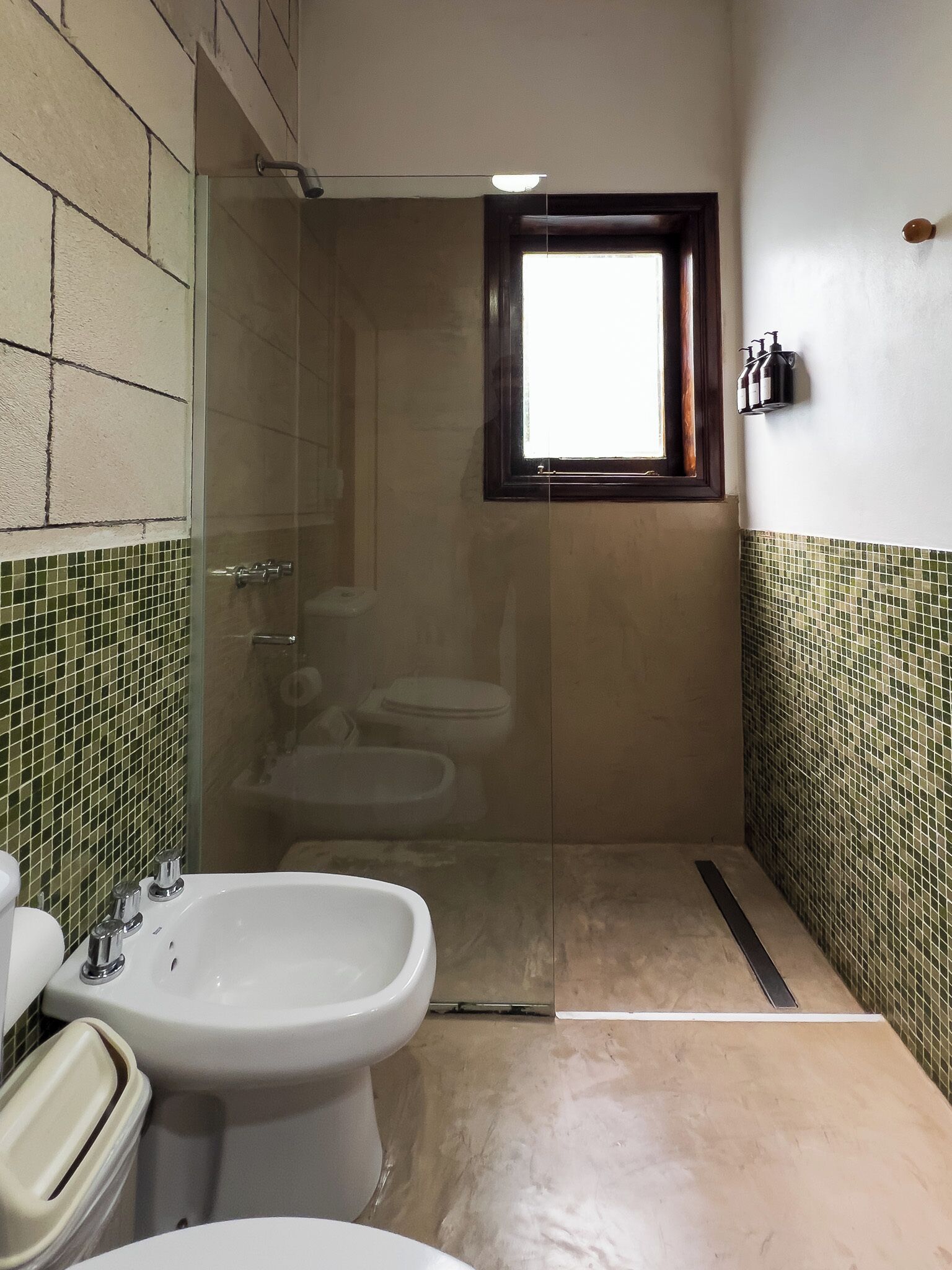A small bathroom with a glass-enclosed shower, a toilet, and a bidet.