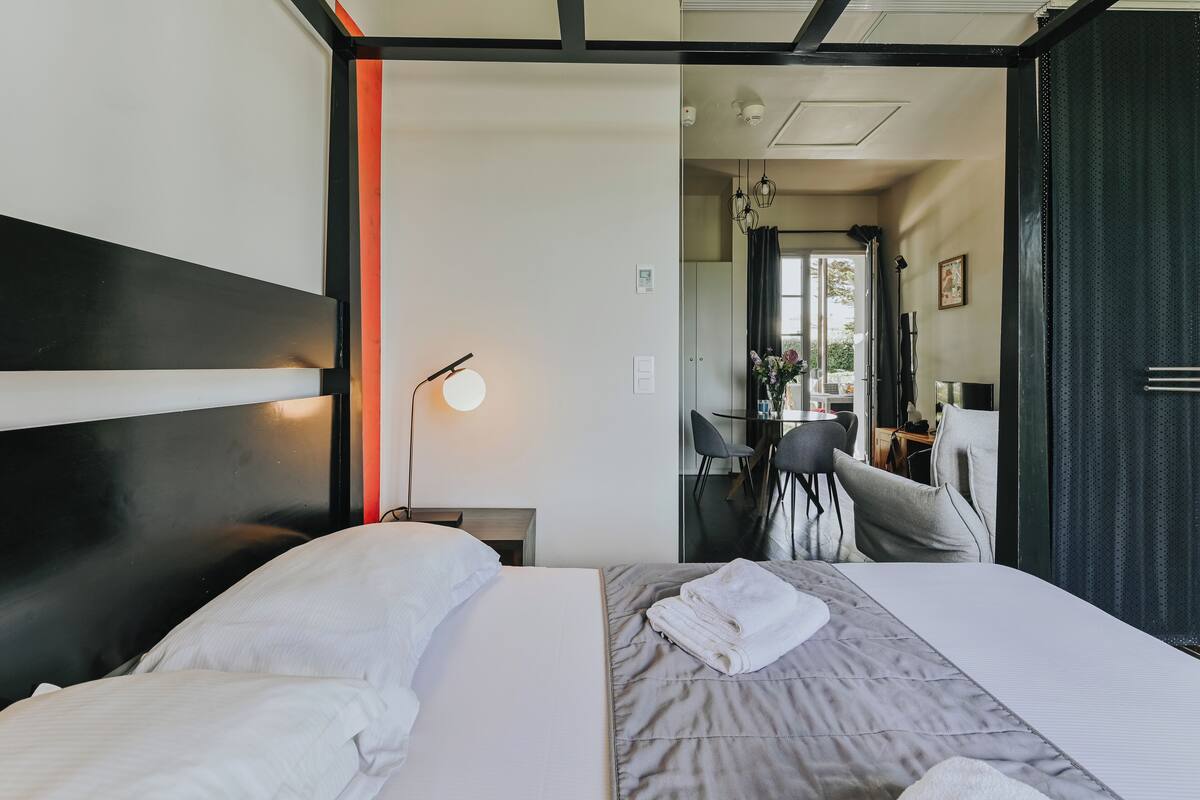Une chambre d’hôtel avec un lit, un bureau et une chaise.