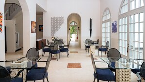 A spacious hotel lobby with high ceilings, arched windows, and modern furniture.