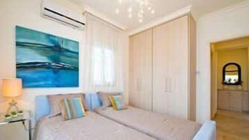 A bedroom with a bed, a nightstand, a painting, and a wardrobe.