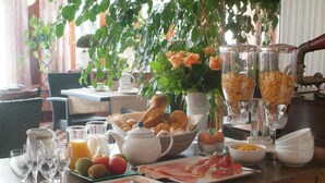 A breakfast table with various food items, including eggs, bread, and fruits. - Belvedere (Heuvelland)