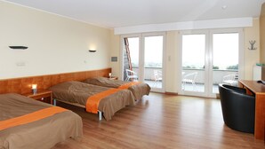 A hotel room with two beds, a balcony with a chair, and a trash bin. - Belvedere (Heuvelland)