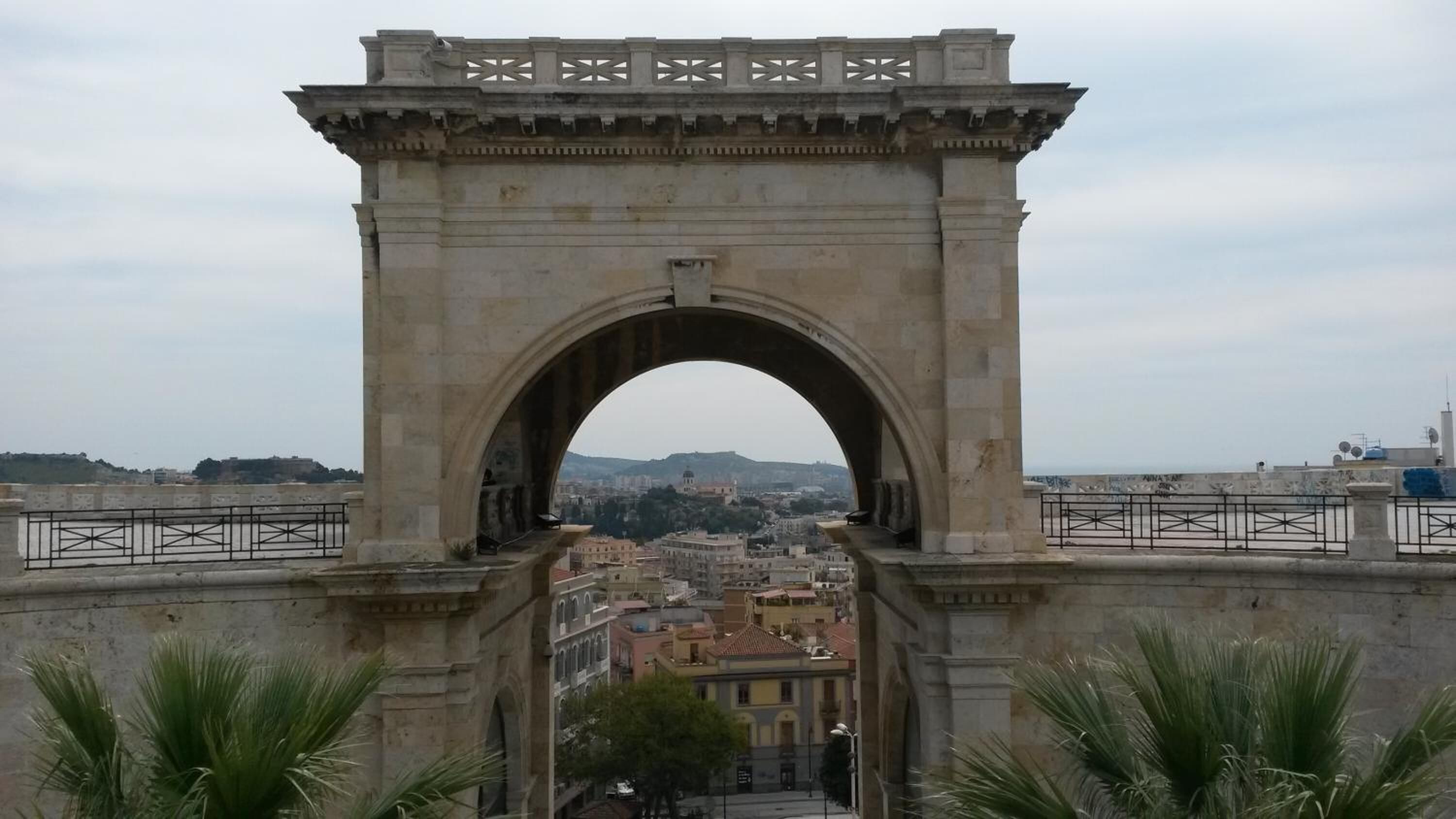 A stone archway with a view of a cityscape beyond.