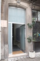 Uma porta com painel de vidro e um vaso de planta ao lado.