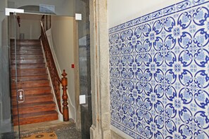 Uma escadaria com degraus de madeira e corrimão, dando acesso a um andar superior.