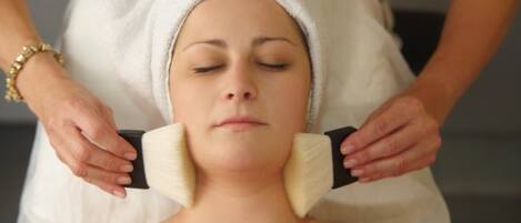 A person receiving a facial treatment with a towel wrapped around their head.