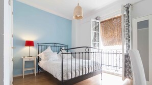 Una camera da letto con un letto con struttura in metallo, un comodino con una lampada e una finestra vista.