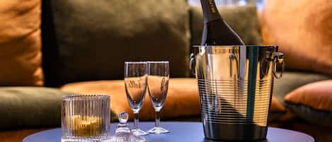 A table with a champagne bottle, glasses, and a crystal decanter.