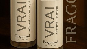 Twee flessen Fragonard VRAI douchegel en shampoo op een houten ondergrond.
