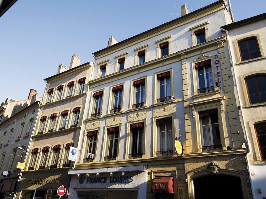 Ett hotell med flera våningar, byggt i en klassisk europeisk arkitektonisk stil, med symmetriskt placerade fönster och balkonger.
