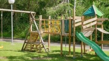 Eine Spielgeräte-Konstruktion aus Holz mit Rutsche und Kletterelementen.