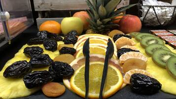 Uma tábua de frutas com diversas frutas frescas e secas.