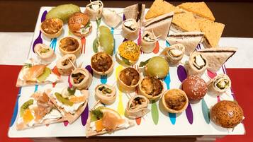 A variety of appetizers arranged on a white plate with colorful accents.