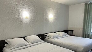 Two single beds with white linens in a room with textured white walls and two wall-mounted lights. - Citotel Du Tigre (Verdun)