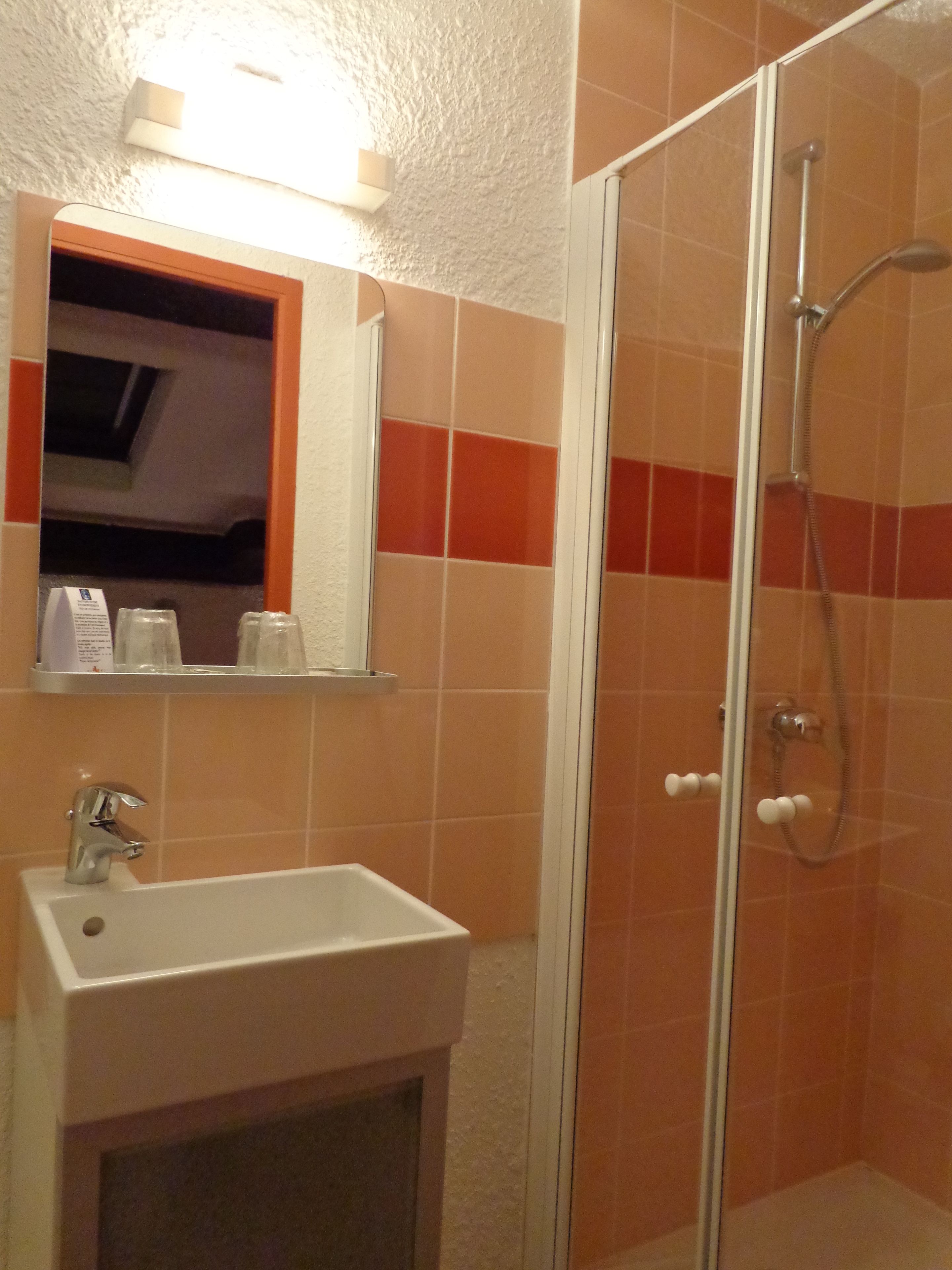 Un baño con lavamanos, espejo y ducha.