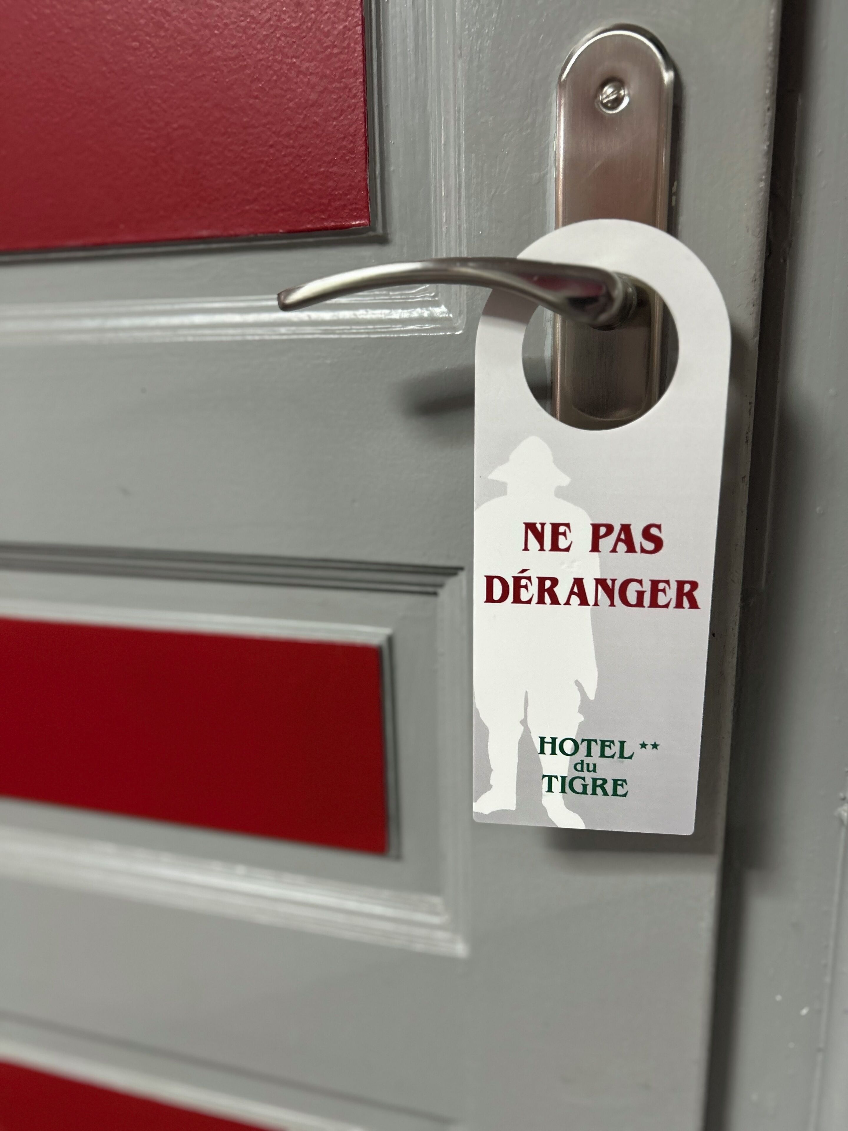 A hotel door with a sign that reads "NE PAS DÉRANGER HOTEL du TIGRE".