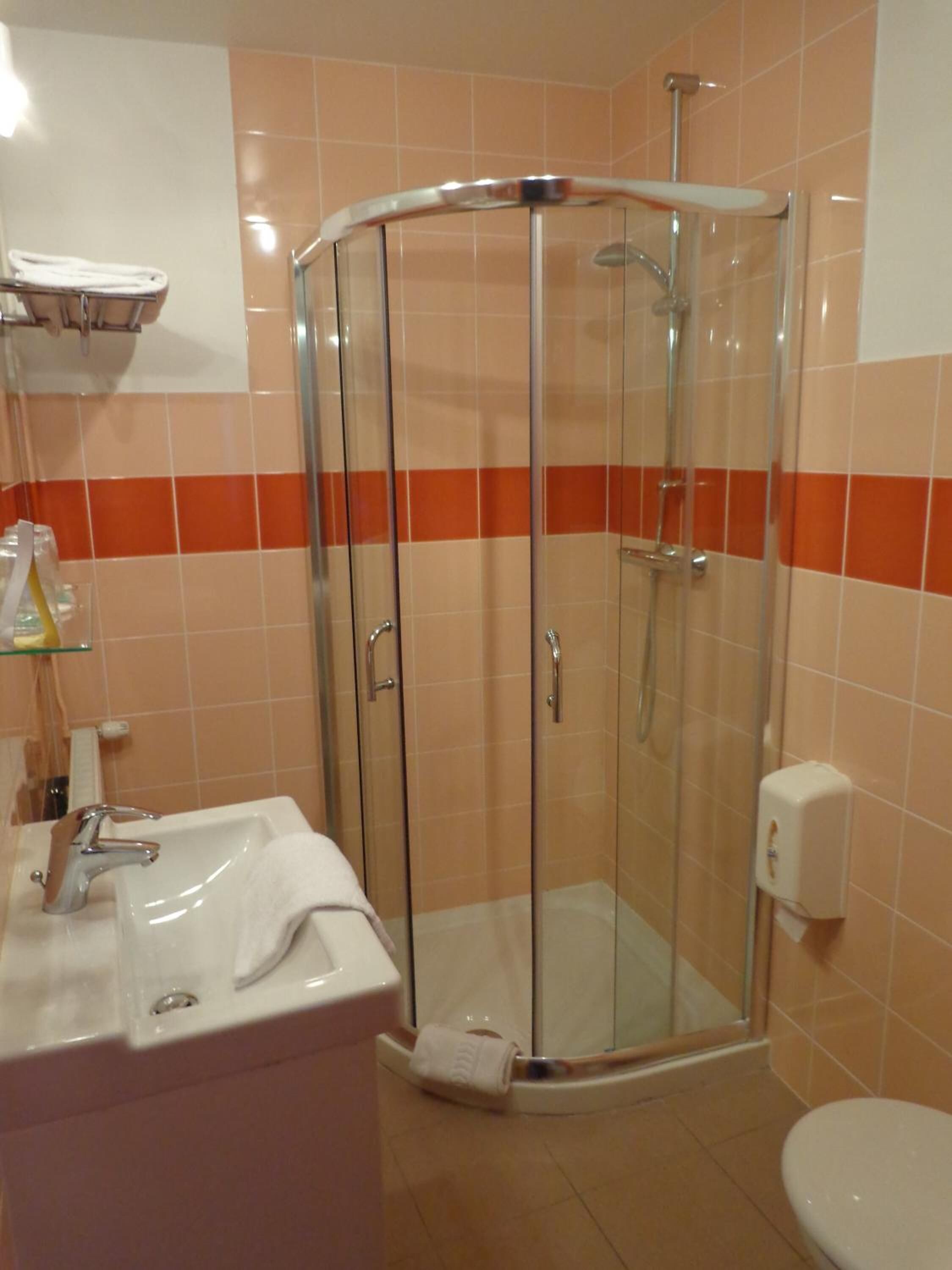 Ein Badezimmer mit Duschkabine, Waschbecken und Toilette.