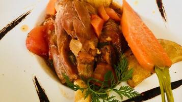Une assiette contenant un plat de viande, des légumes et une garniture.