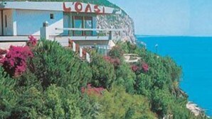 A coastal building with a sign reading "LOASI". - L'Oasi (Dorgali)