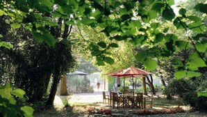 A gazebo with a table and chairs in a garden setting. - Citotel Avallon Vauban (Avallon)