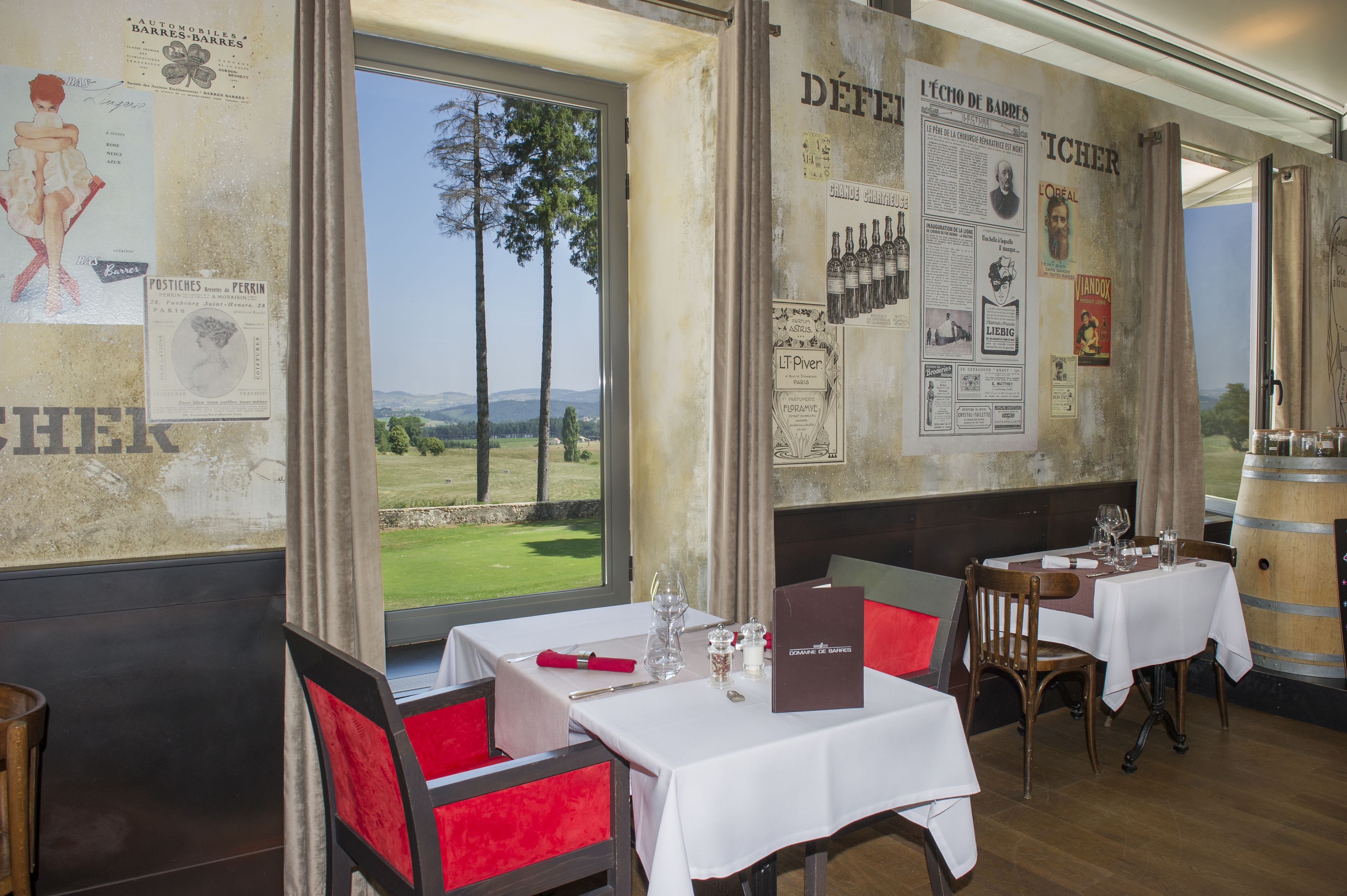 Un restaurante con mesas dispuestas para comer, vistas al exterior y varios carteles en las paredes.
