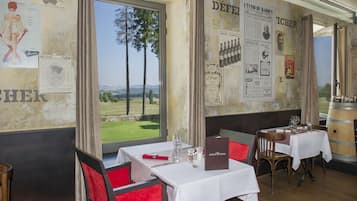 Un restaurante con mesas dispuestas para comer, vistas al exterior y varios carteles en las paredes.