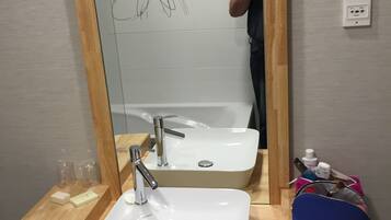 Ein Badezimmer mit einem großen Spiegel, zwei Waschbecken und einer Holzausstattung.