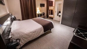 A hotel room with a bed, a desk, a chair, a wardrobe, and a television. - Hôtel des Bourbons (Montlucon)