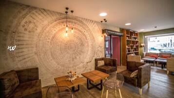A cozy lounge area with a large circular wall design, comfortable seating, and a visible reception desk.