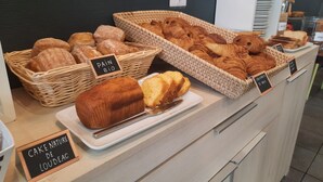 Una vitrina de panadería con diversos productos horneados, como pan y pasteles.