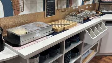 A breakfast buffet area with various food items and condiments.