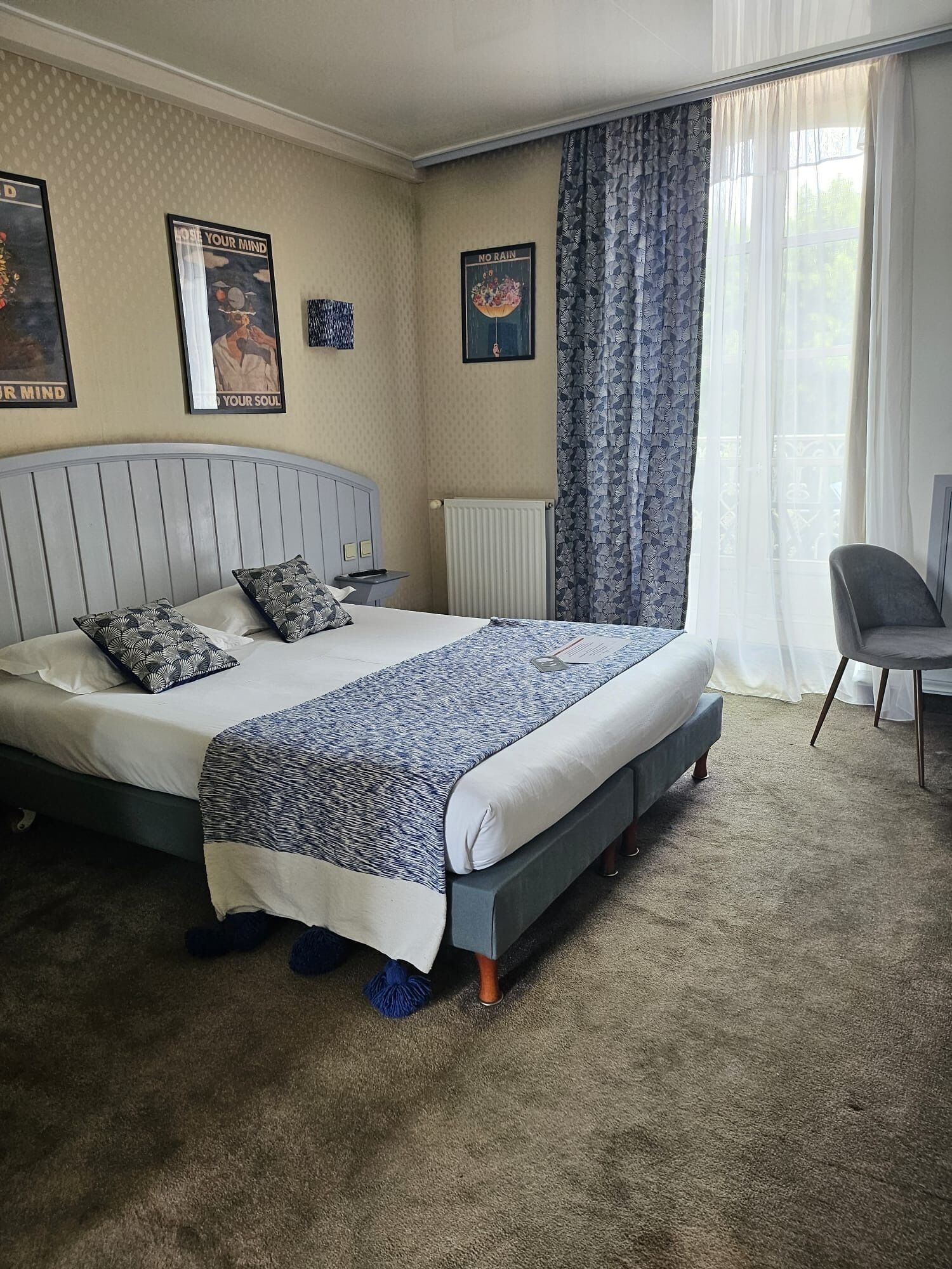 A neatly arranged bedroom with a bed, a chair, and a radiator.