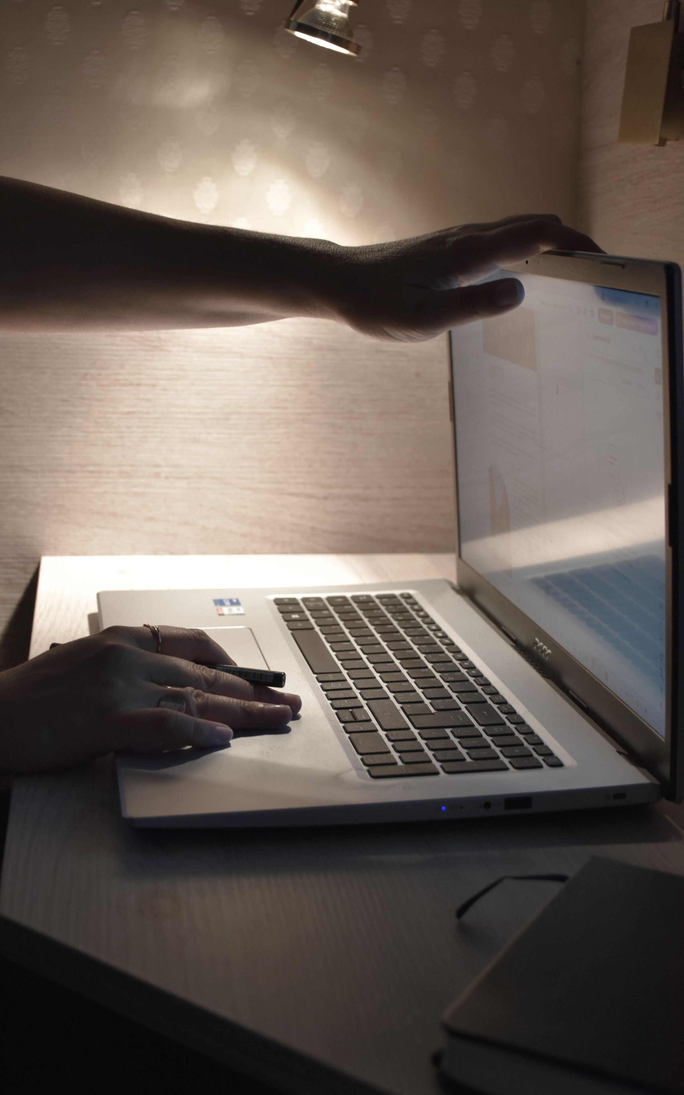 Una laptop sobre un escritorio, con una mano escribiendo en el teclado.
