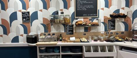 A breakfast buffet area with various food items and breakfast options displayed on a counter.