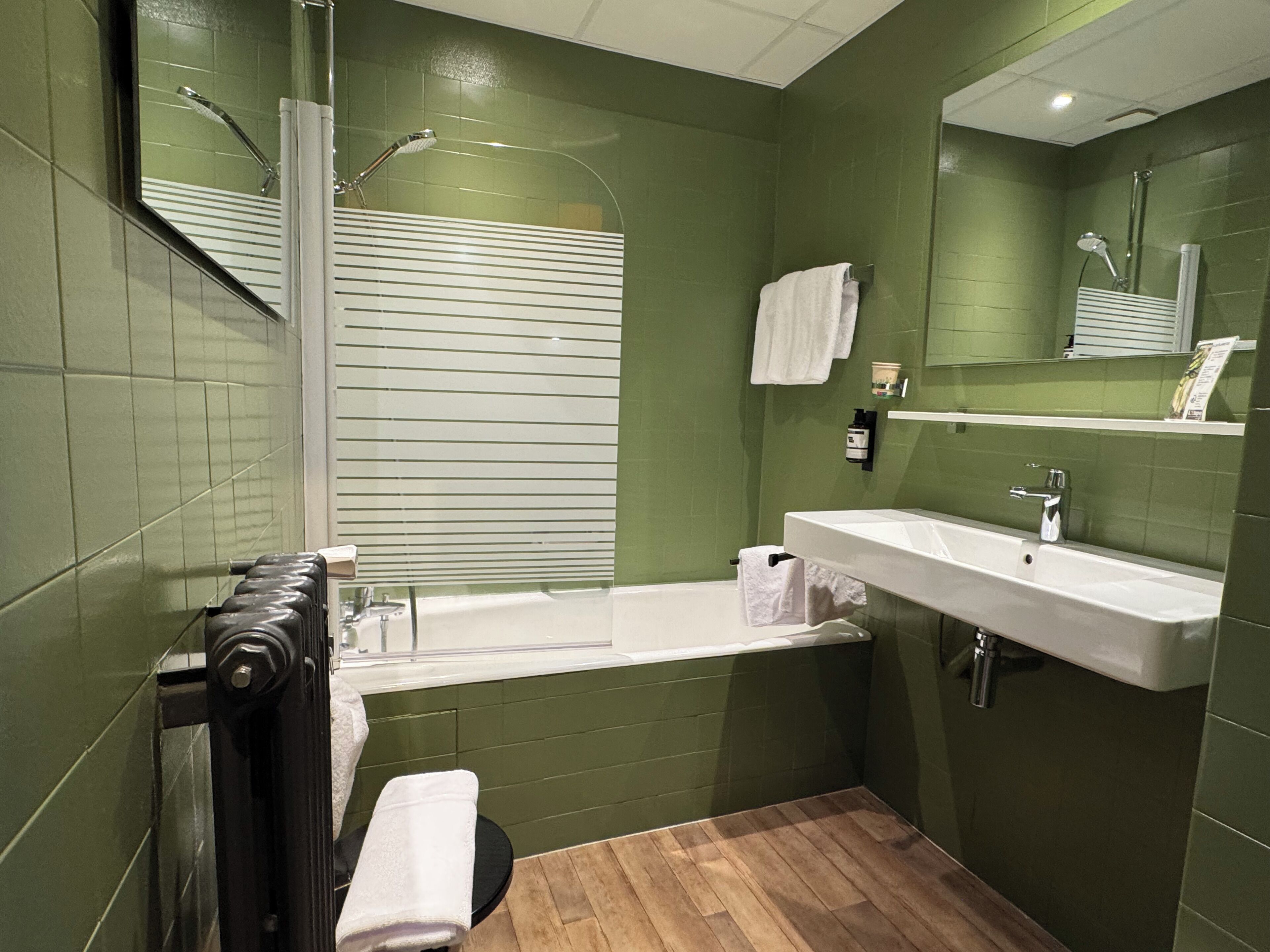 Une salle de bain avec une baignoire, un lavabo et un miroir.