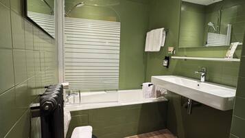 Une salle de bain avec une baignoire, un lavabo et un miroir.