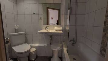 Une salle de bain équipée de toilettes, d’un lavabo et d’une baignoire.