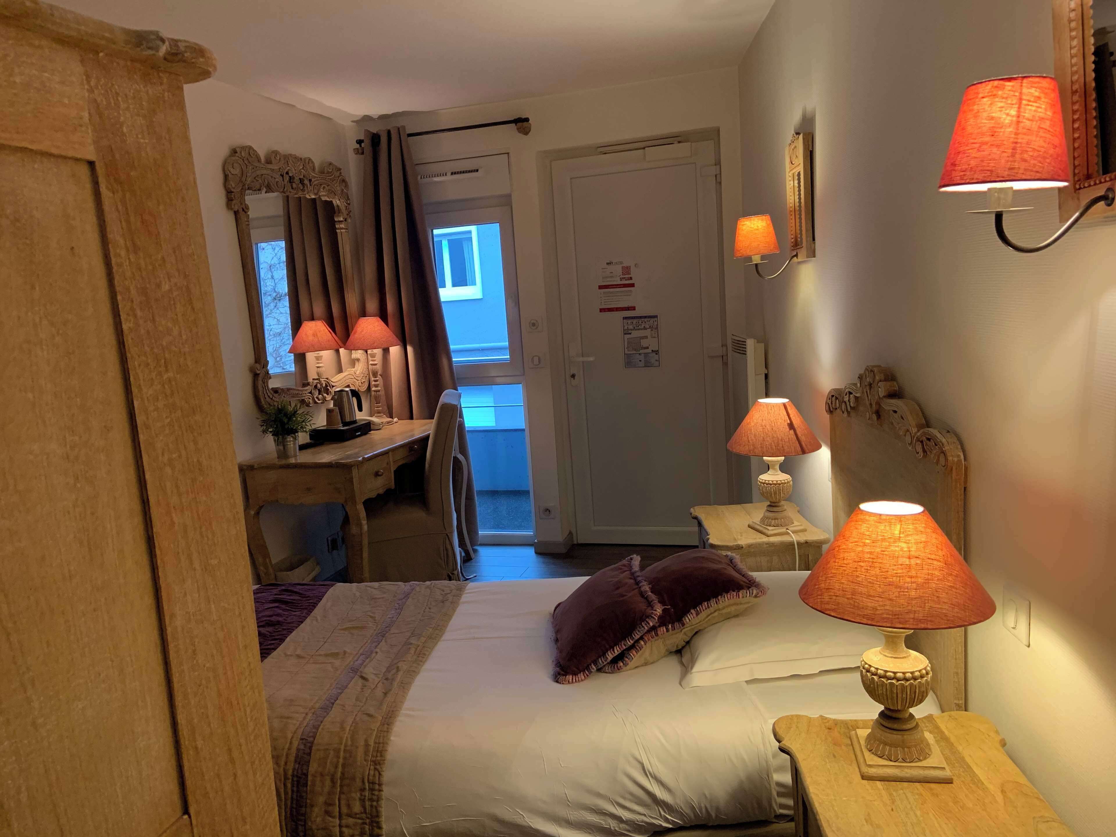 Une chambre à coucher avec un lit, des lampes de chevet, un bureau et une chaise.