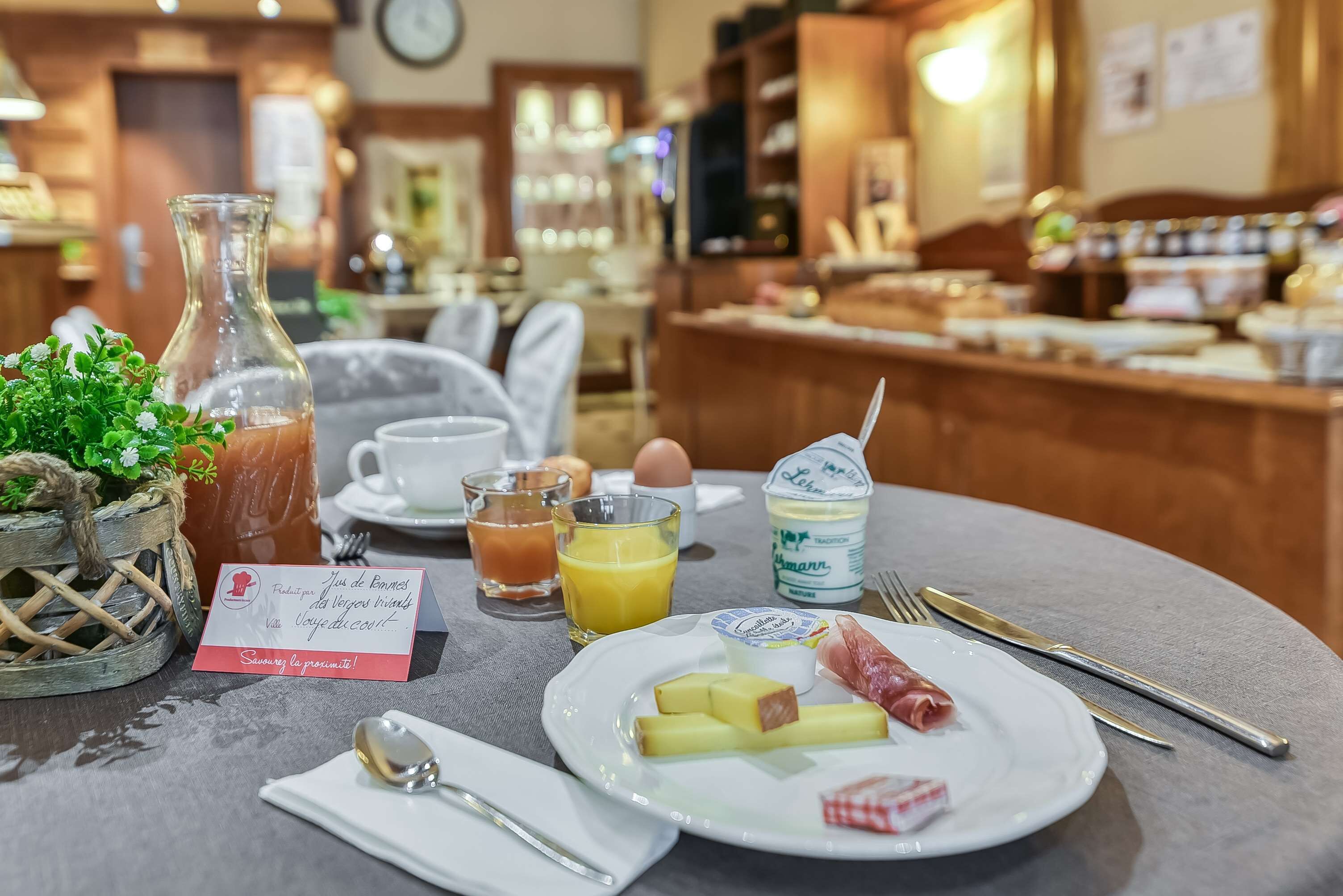 A breakfast setting with a plate of food, a glass of orange juice, a bottle of milk, and a menu card.