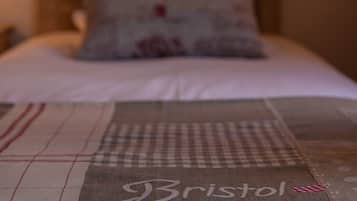 A bed with a pillow and a blanket with the word "Bristol" on it.