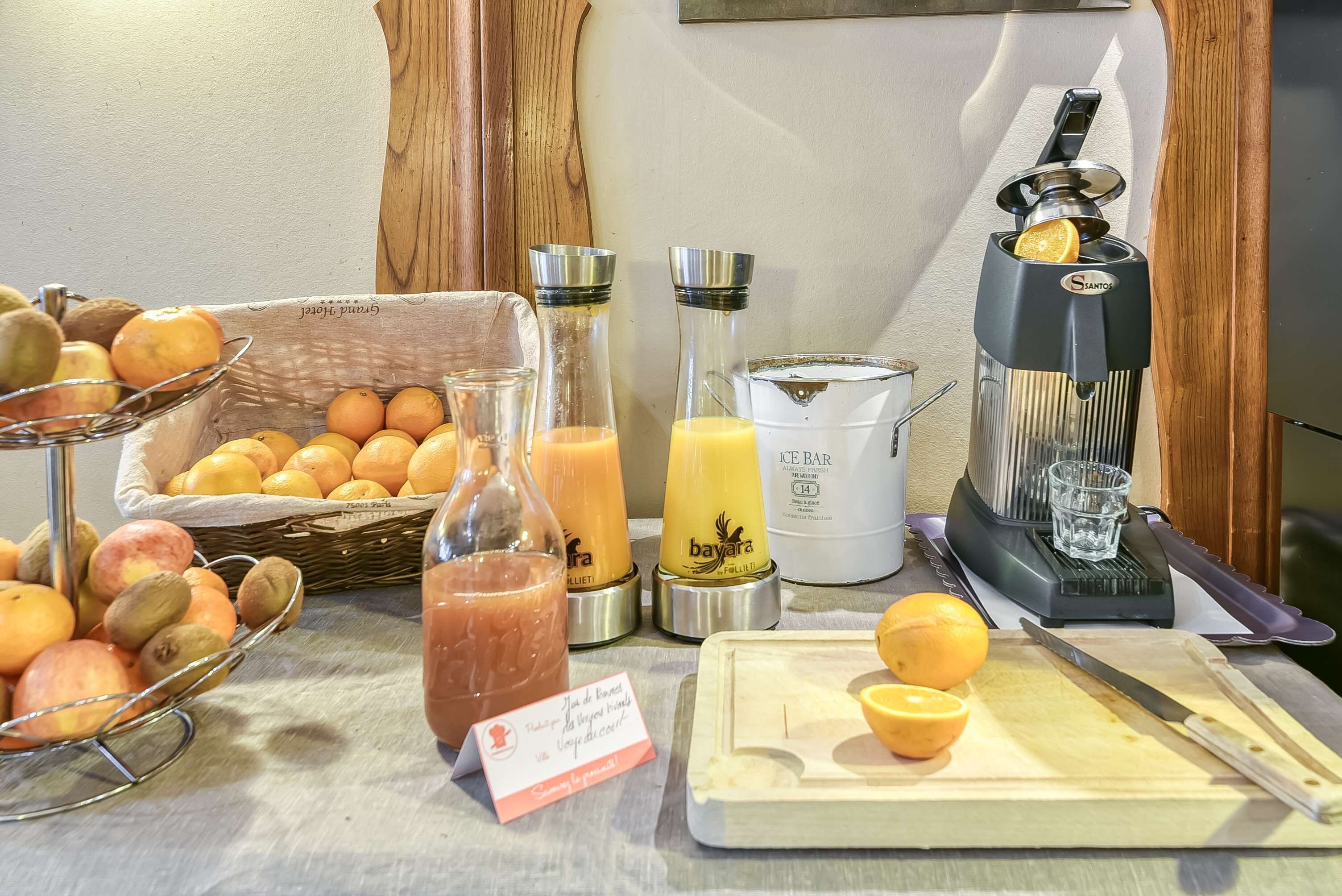Una mesa con frutas frescas, un exprimidor y una licuadora.