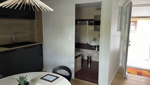 Una cocina moderna con encimera de madera y lámpara colgante.