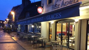 Un restaurante llamado 'R6Z Apels' con terraza y un cartel que indica 'Bar - Restaurante - Helados'.