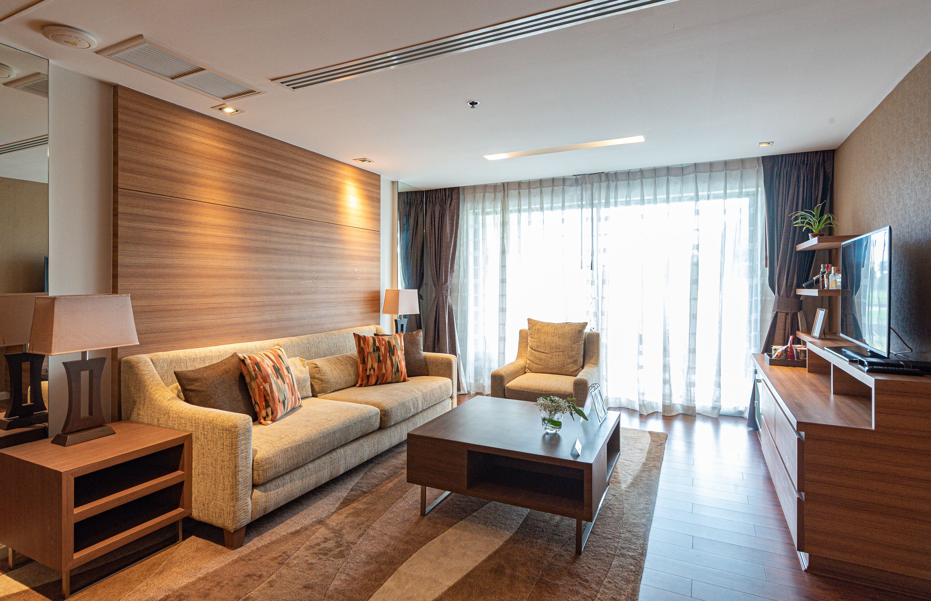 A modern living room with a sofa, coffee table, and TV stand.