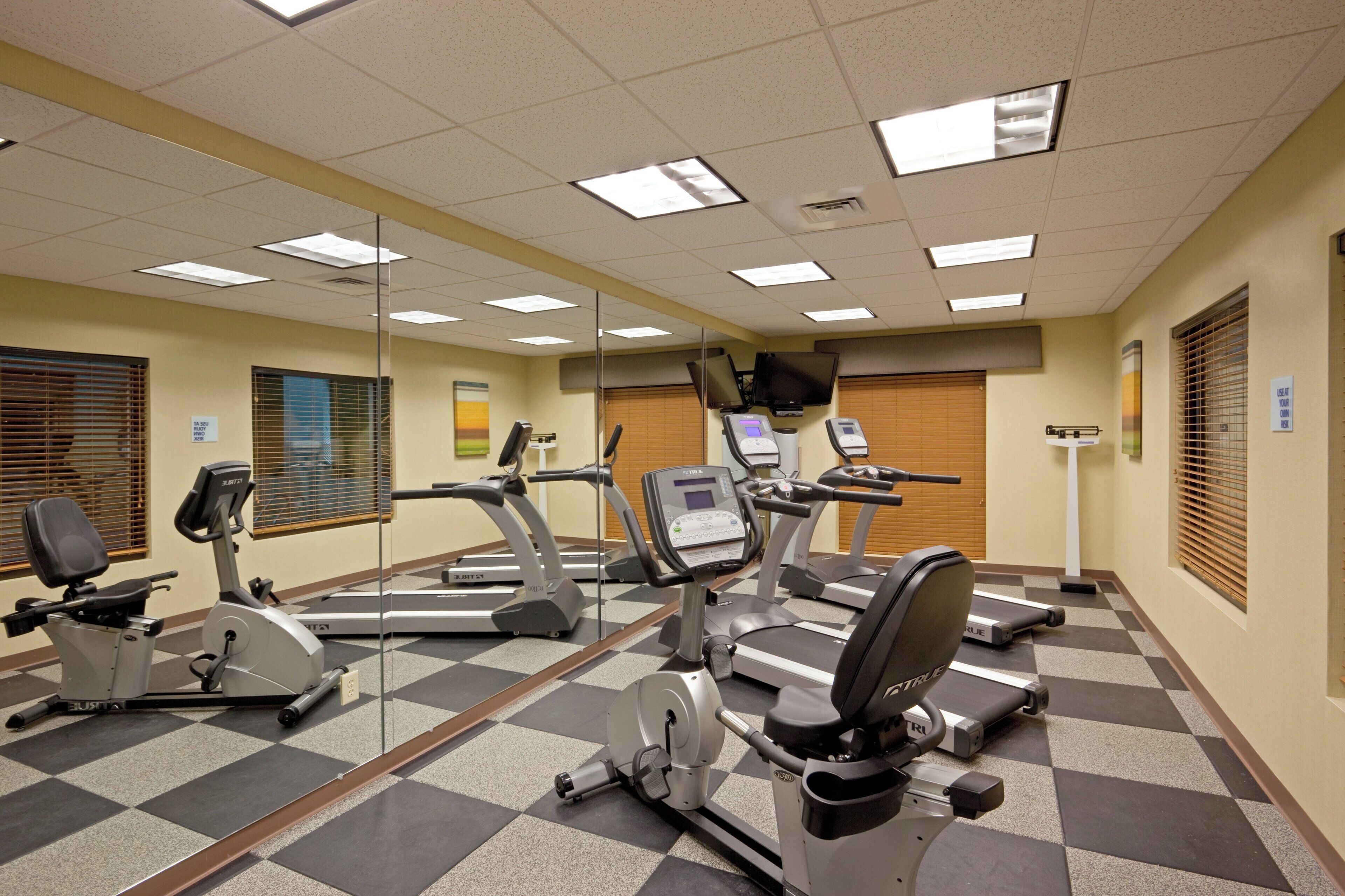 Ein Fitnessstudio mit mehreren Laufbändern, Ergometer und Trainingsgeräten.